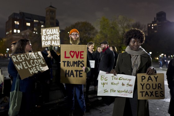 Image: Protesters hold banners during a protest against President-elect Donald Trump