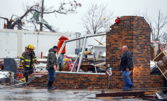 Image: A Rosalie firefighter helps remove debris from the Rosalie Plaza after a tornado ripped through the town