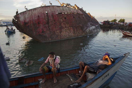In this Nov. 30, 2016 photo, fishermen rest after selling their catch at the fish market in the port of Cumana, Sucre state, Venezuela.