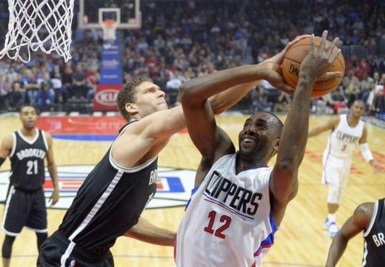 Los Angeles Clippers forward Luc Mbah a Moute (R), of Cameroon, shots as Brooklyn Nets center Brooke Lopez defends in Feb. 29, 2016 game.