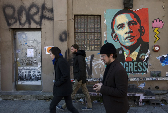 Image: People walk past a campaign poster for Democratic presidential candidate Barack Obama