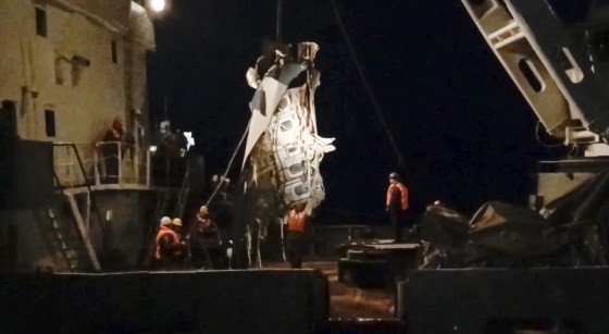 Image: Rescuers lift a fragment of a plane