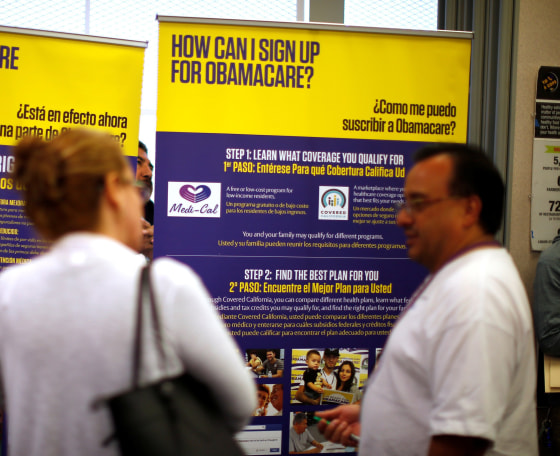 Image: FILE PHOTO - Julian Gomez explains Obamacare to people at a health insurance enrolment event in Commerce