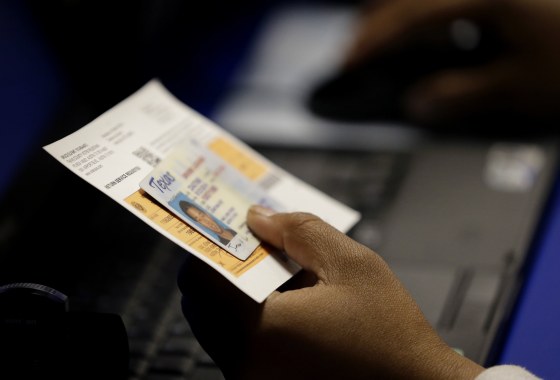 Image: In this Feb. 26, 2014, file photo, an election official checks a voter's photo identification at an early voting polling site in Austin, Texas.