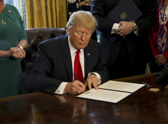 Image: U.S. President Donald Trump signs Executive Orders in the Oval Office of the White House, including an order to review the Dodd-Frank Wall Street to roll back financial regulations of the Obama era Feb. 3, 2017.