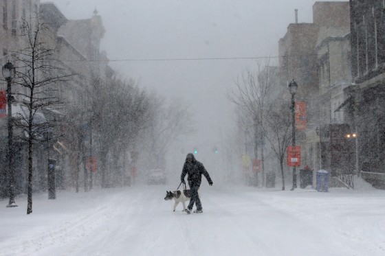 Image: A man walks his dog in heavy falling snow on Main Street in the village of Nyack, New York, a suburb north of New York City, Feb. 9, 2017.