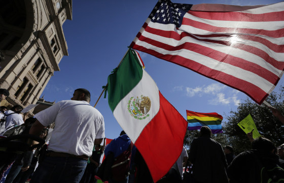 Image: A man hold the U.S and Mexico flags during a march and rally during an immigration protest