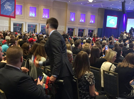 Image: A CPAC employee collects Russian flags that were handed out as a prank during the conference