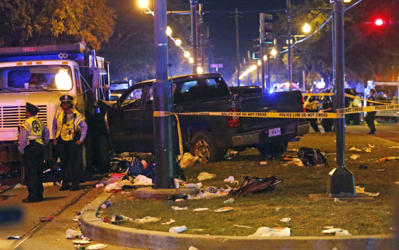 Police next to a pickup truck that slammed into a crowd and other vehicles during the Krewe of Endymion parade Saturday in New Orleans.