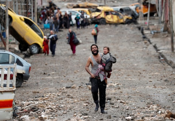 Image: A man cries as he carries his daughter while walking from an Islamic State-controlled part of Mosul towards Iraqi special forces soldiers during a battle in Mosul