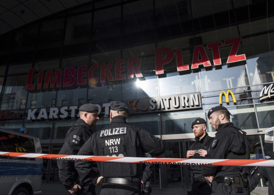 Image: Policemen guard the front of a shopping mall
