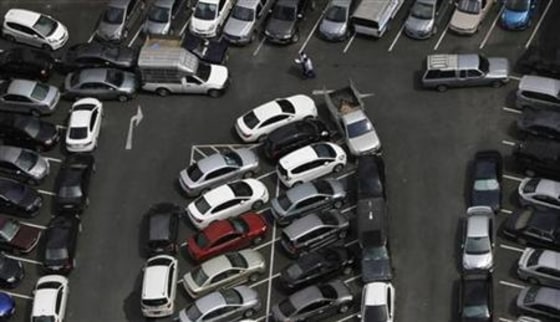 Men walk in a crowded car park in downtown Bangkok