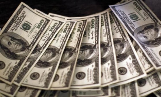 Four thousand U.S. dollars are counted out by a banker counting currency at a bank in Westminster