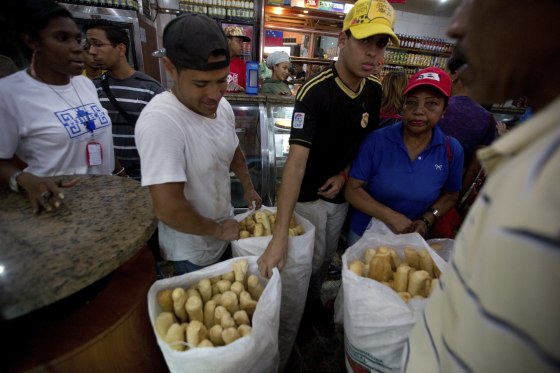 Employees of the Minka state-run bakery carry bags of cheap bread to be distributed to state-run grocery stores in Caracas, Venezuela.