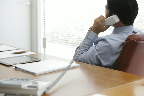 Mature businessman talking on phone in office