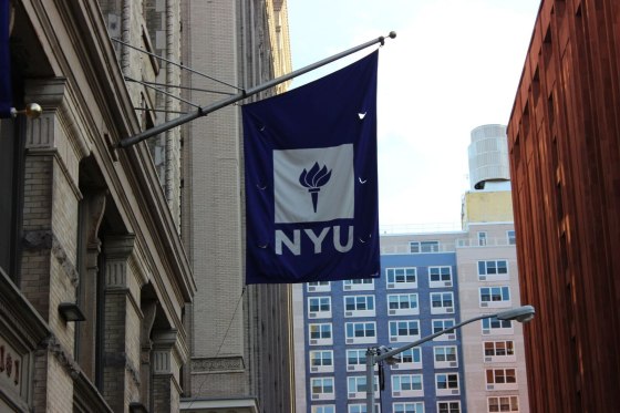A flag of NYU outside of the buildings.