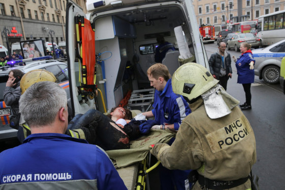 Image: An injured person is helped by emergency services outside Sennaya Ploshchad metro station following explosions in St. Petersburg