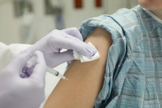 Doctor placing gauze on patient's arm after administering a shot