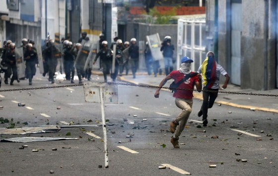 Image: Demonstrators run away during a rally against Venezuela's President Nicolas Maduro's government in Caracas
