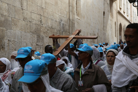 Image: Christian pilgrims carry a wooden cross along the \"Via Dolorosa\" in Jerusalem's Old City Friday.