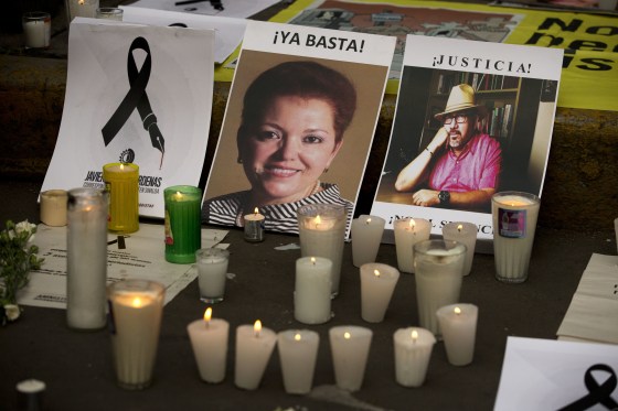 Candles burn in front of pictures of murdered journalists Miroslava Breach, left, and Javier Valdez during a demonstration against the killing of journalists, outside the Interior Ministry in Mexico City, Tuesday, May 16, 2017.