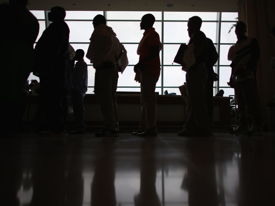 Image: People stand in line to apply for a job during a job fair in Miami