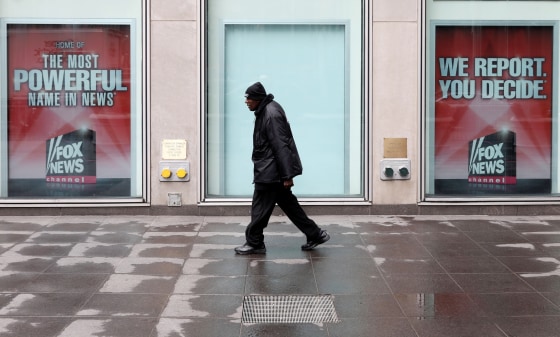 Image: A man walks past News Corporation Headquarters in New York