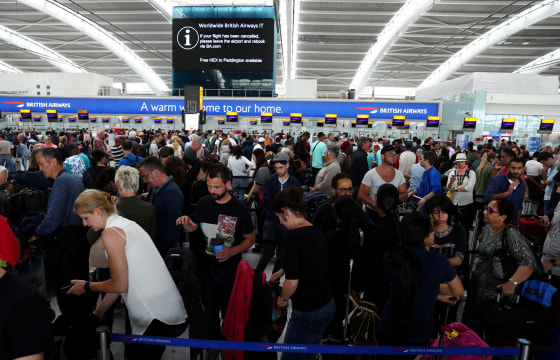 Image: People wait with their luggage at the British Airways check in desks at Heathrow Terminal 5 in London