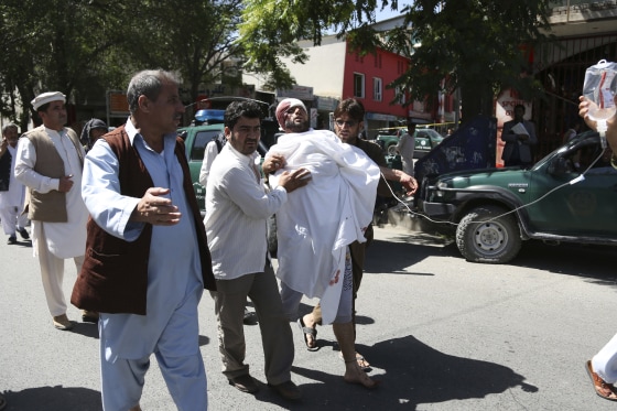 Image: People carry an injured man after a suicide attack in Kabul