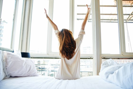 Image: woman stretching in bed