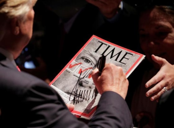 Candidate Donald Trump signs a magazine with his picture on it at a campaign rally in Raleigh, North Carolina, July 2016. REUTERS/Joshua Roberts