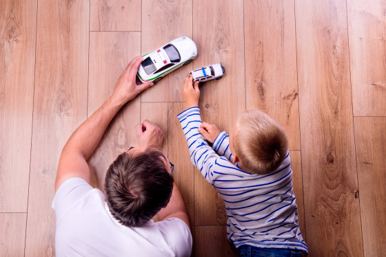Image: A father with his son playing with cars.