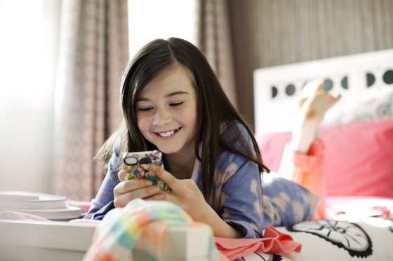 Image: Smiling Girl Using Smart Phone in Bed