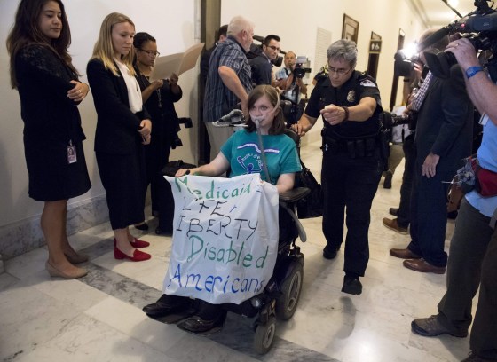 Image: U.S. Capitol Police remove a protester outside the office of Senate Majority Leader Mitch McConnell