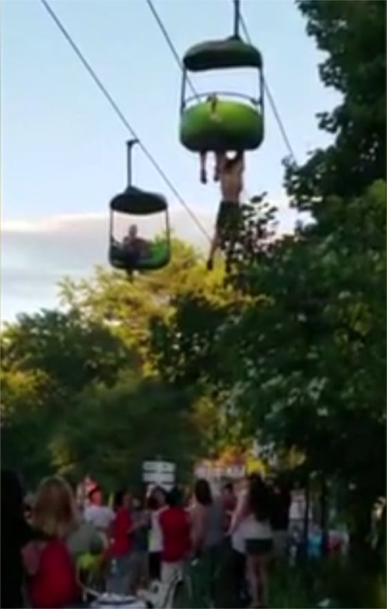Image: A 14-year-old hangs from a amusement park ride before falling into the arms of good Samaritans
