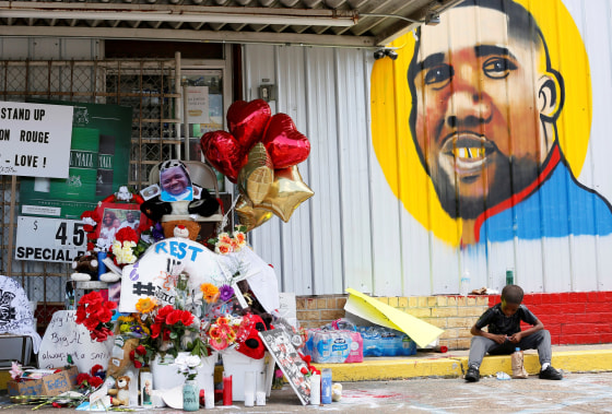 Image: FILE PHOTO: A boy sits next to a makeshift memorial outside the Triple S Food Mart where Alton Sterling was fatally shot by police in Baton Rouge