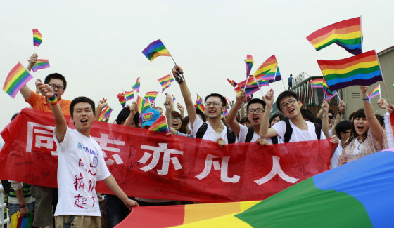 Image: Youngsters hold rainbow flags during their anti-discrimination parade in Changsha.
