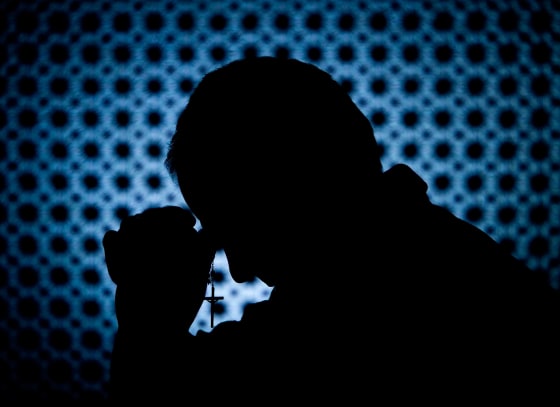 Image: Priest in Confession Booth with Cross