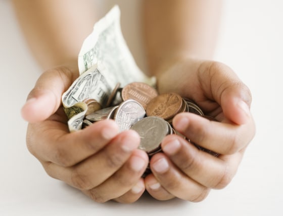 Image: A child holds money in her hands