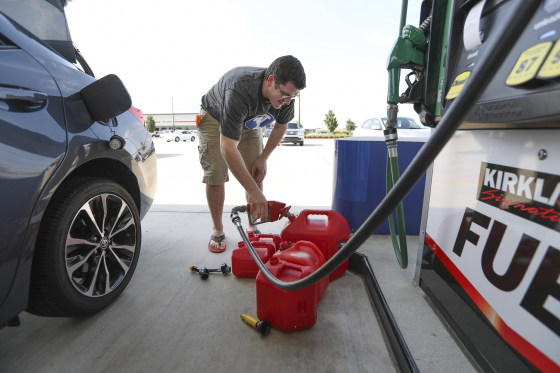 Image: A man fills gas cans in preparation for the storm