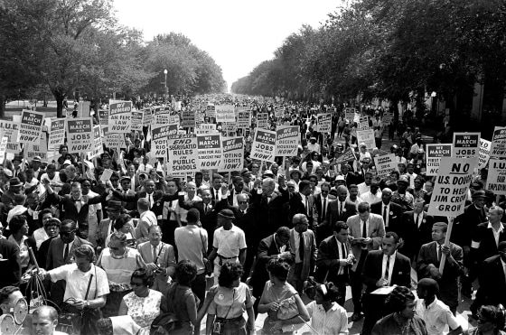 Image: Dr. Martin Luther King Jr., center left with arms raised, marches along Constitution Avenue with other civil rights protesters carrying placards, from the Washington Monument to the Lincoln Memorial during the March on Washington, Aug. 28, 1963.