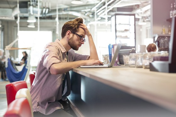 Focused businessman working at laptop in cafe