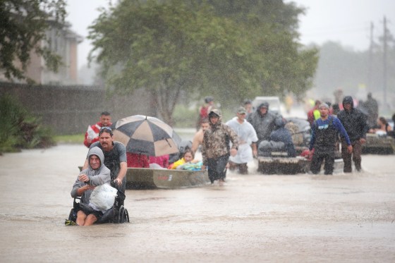 Image: People are rescued from a flooded neighborhood in Houston