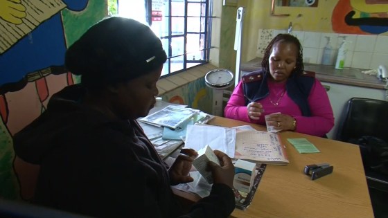 Image: An HIV positive woman, left, receives antiretroviral drugs at a clinic in Hammanskraal, South Africa.