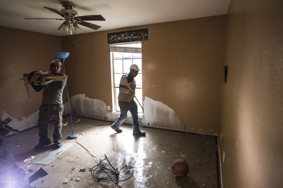 Image: A construction crew cleans out the home of Kenny Licona, which was flooded out from Tropical Storm Harvey