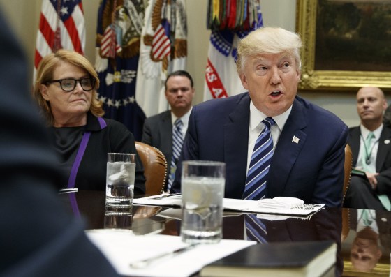 Image: President Donald Trump, seated next to Sen. Heidi Heitkamp, D-N.D.