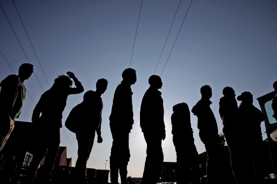 Image: Migrants from Ethiopia and Eritrea queue in line during a food distribution near the former \"jungle\" in Calais