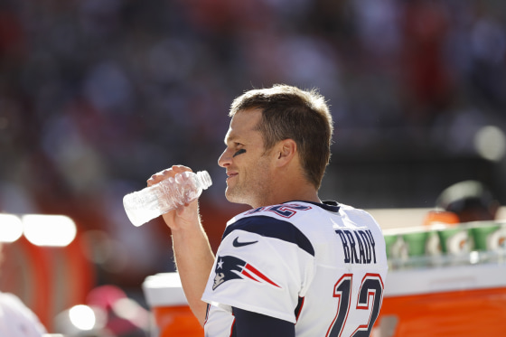 Image: Tom Brady drinks on the sidelines during an NFL football game