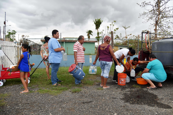 Image: People take water from a tank in Vega Baja, Puerto Rico