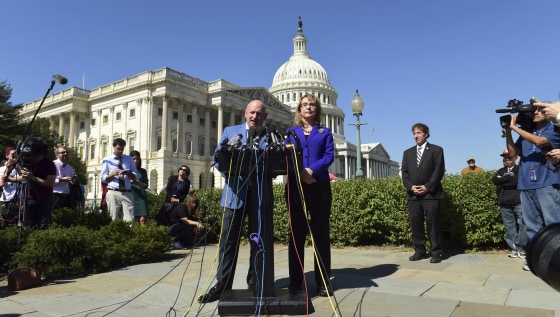 Image: Former Rep. Gabrielle Giffords, D-Ariz., right, listens as her husband Mark Kelly speaks on Capitol Hill